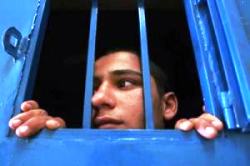 Uomo carcerato si affaccia alla finestra della sua cella